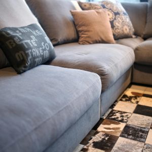 A cozy gray corner sofa adorned with patterned cushions in a stylish indoor living space.