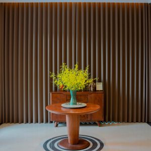 Stylish interior featuring a wooden table, vase with yellow flowers, and elegant curtains.
